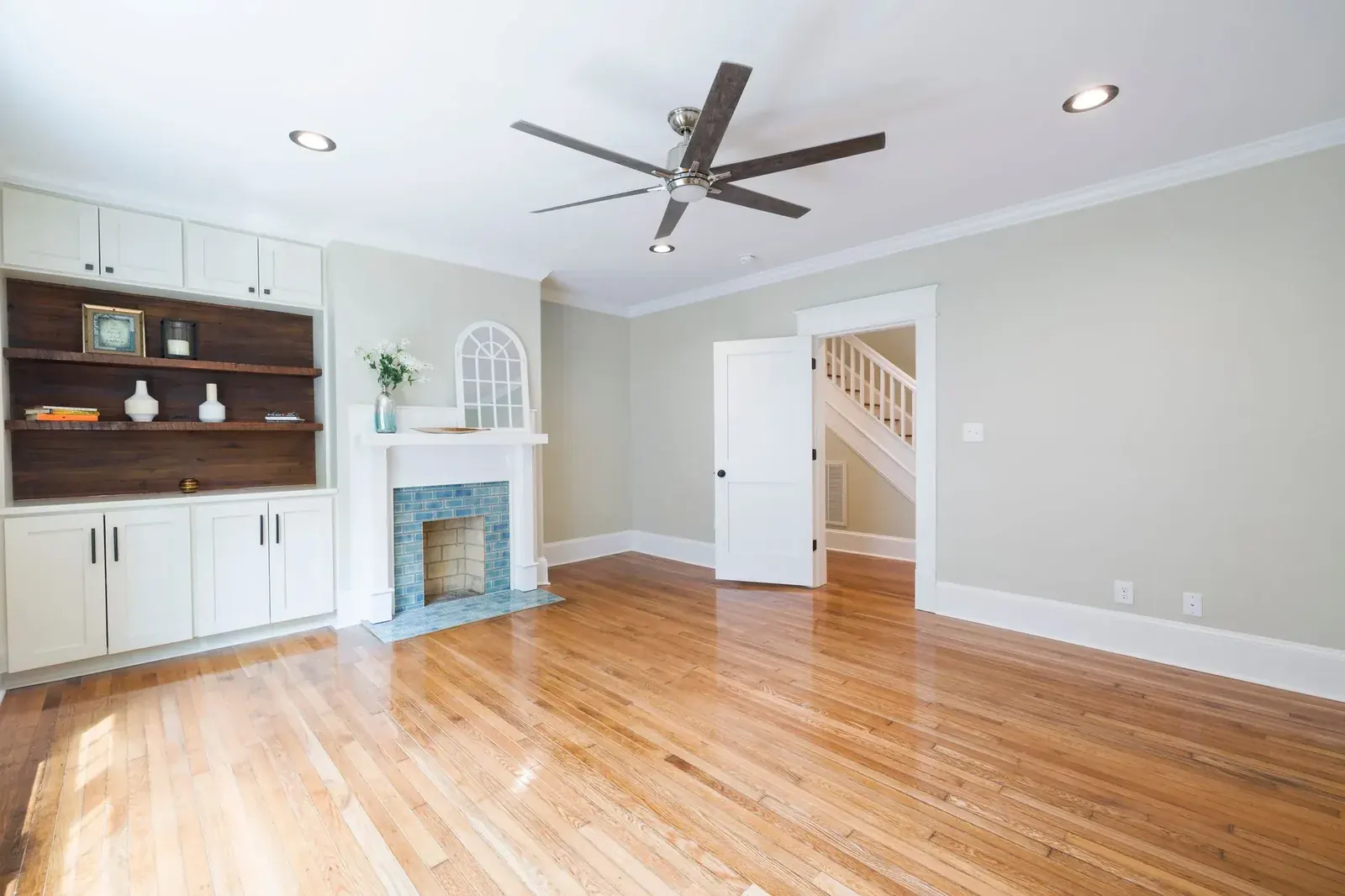 Living room with warm hardwood floors and painted built-ins