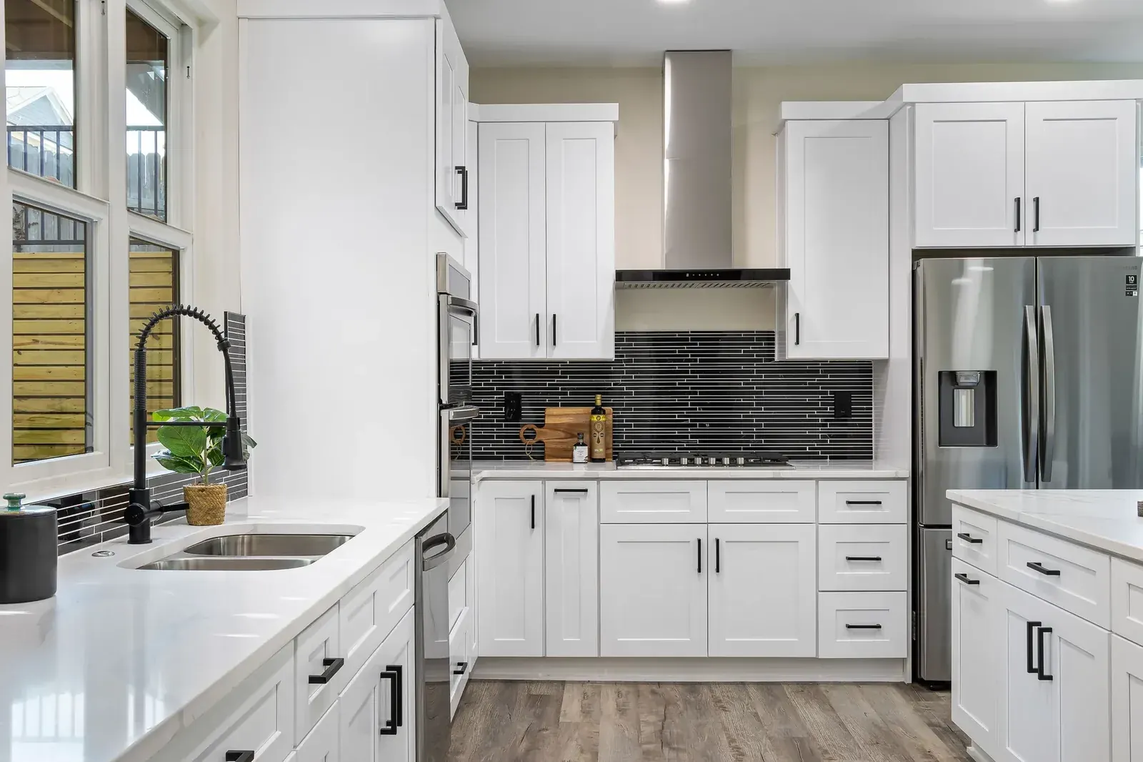 White shaker cabinets, stainless appliances and wood-look flooring