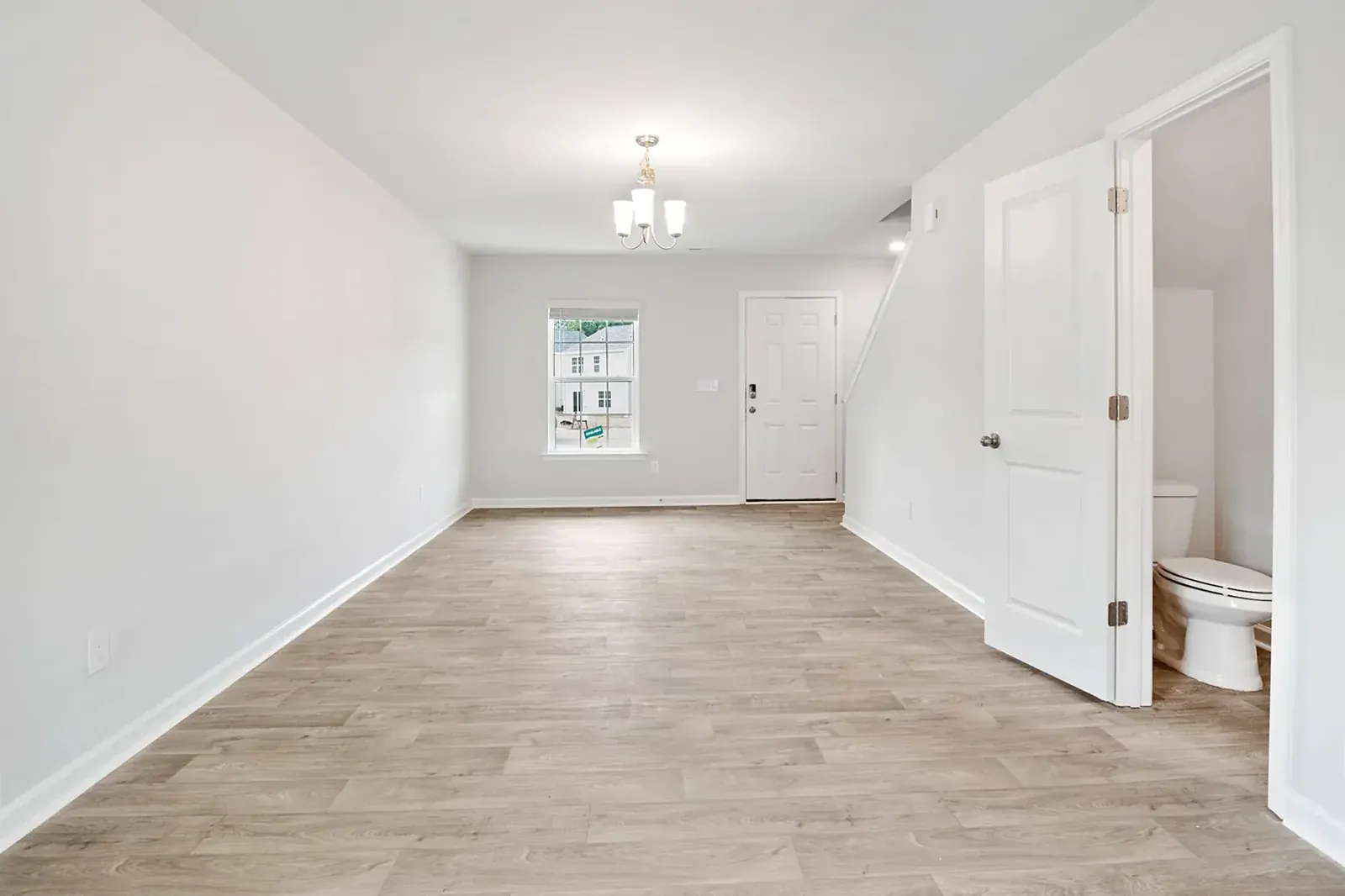Open hallway and living area with light wood-look plank flooring