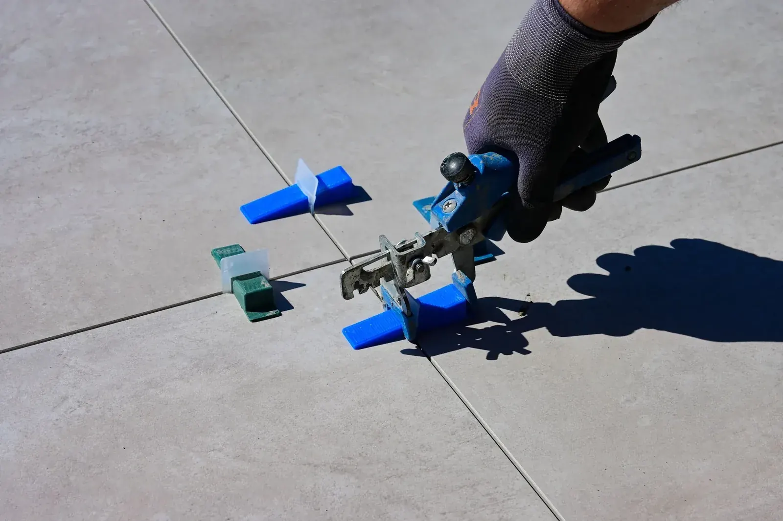 Large-format floor tile set with a leveling system and spacers