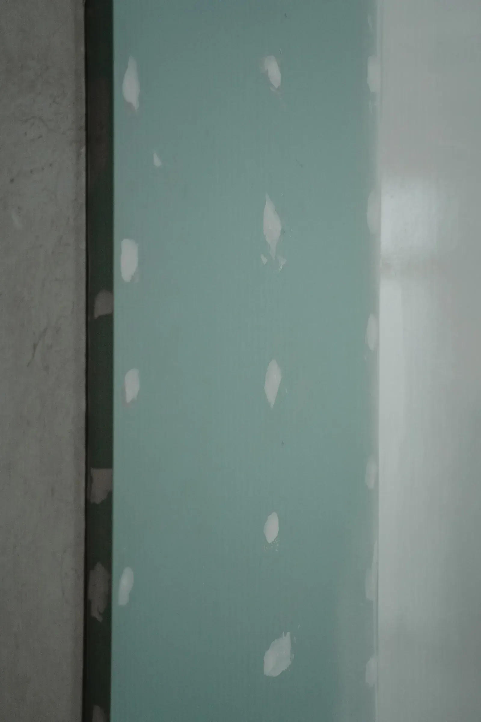 Wall section rebuilt with moisture-resistant board and patched seams
